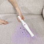 Travel sterilization lamp stick in white ABS material with a purple light button and ergonomic grip design shown disinfecting fabric.
