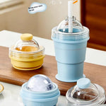 Foldable silicone ice ball cup and water bottle mold for coffee and juice drinks in lemon yellow and sky blue colors
